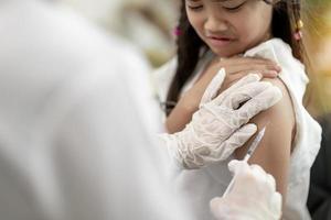 vaccination covid-19 réussie. jolie petite fille tout en étant immunisée contre le coronavirus photo