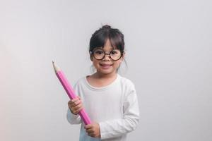 jeune fille excitée tenant de gros crayons dans ses mains. retour à l'école. photo