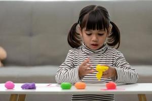 les enfants asiatiques jouent avec des formes de moulage d'argile, apprenant par le jeu photo