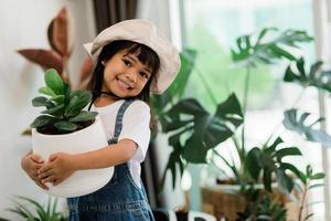 plantes en pot à la maison tenues par un enfant mignon photo