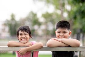 deux petits enfants asiatiques garçon et fille heureux et souriant dans le parc photo