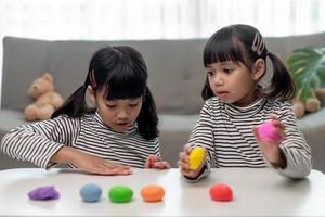 la petite fille apprend à utiliser de la pâte à modeler colorée dans une pièce bien éclairée photo