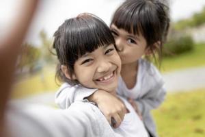 un enfant asiatique heureux prend un selfie dans le parc. photo