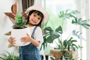 plantes en pot à la maison tenues par un enfant mignon photo