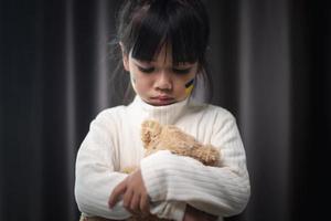 un enfant avec le drapeau de l'ukraine pleure. tristesse nostalgie espoir. les larmes d'enfants de la guerre. évacuation des civils. liberté à l'ukraine photo