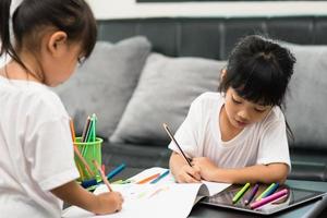 coronavirus covid-19 et apprentissage à domicile, concept d'enfant à l'école à la maison. les petits enfants étudient l'apprentissage en ligne à la maison avec un ordinateur portable. photo