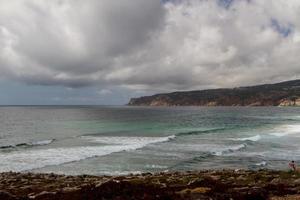 les vagues se battent sur la côte rocheuse déserte de l'océan atlantique, le portugal photo