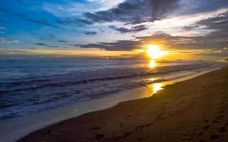 paysage de plage spectaculaire avec coucher de soleil nuageux photo