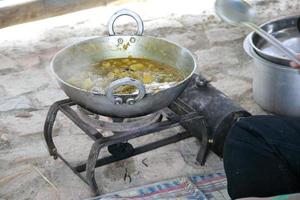 poêle en fer sur une cuisinière portable cuisinant des plats indiens en voyage, en inde. curry dans une casserole bouillante. photo