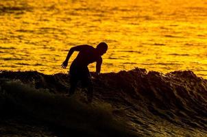 surfeur silhouette au coucher du soleil photo