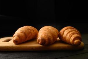 croissants frais sur un fond en bois. photo