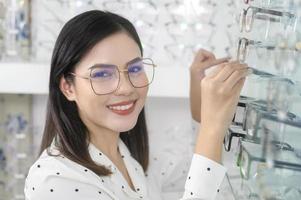 jeune cliente choisissant des lunettes dans un centre optique, concept de soins oculaires. photo