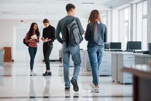 aller à la réunion. groupe de jeunes marchant dans le bureau pendant leur pause photo