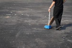 nettoyeur de déchets de balayage dans un grand espace extérieur asphalté à midi. photo