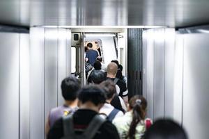 les voyageurs, les passagers marchent dans l'avion via le quai de la ligne de tubes, à l'intérieur de la passerelle. photo