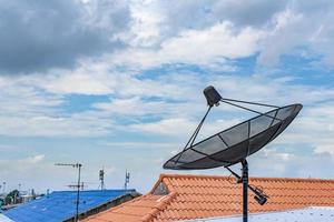 récepteur satellite de télévision numérique sur le toit avec nuageux dans le fond du ciel. photo