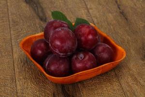 tas de prunes dans le panier en bois photo