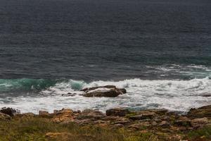 les vagues se battent sur la côte rocheuse déserte de l'océan atlantique, le portugal photo