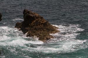 les vagues se battent sur la côte rocheuse déserte de l'océan atlantique, le portugal photo