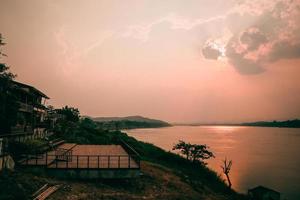 chiang khan loei thaïlande paysage maison en bois au bord de la rivière avec le coucher du soleil le soir à la vieille ville de chaing khan loei thaïlande photo