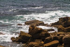 les vagues se battent sur la côte rocheuse déserte de l'océan atlantique, le portugal photo