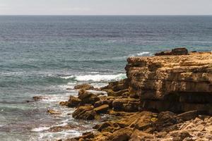 les vagues se battent sur la côte rocheuse déserte de l'océan atlantique, le portugal photo