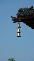 la cloche dorée accrochée au sommet des avant-toits dans un temple de la chine photo