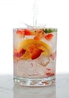 Seltzer drink avec des fruits frais coupés flottant à l'intérieur photo