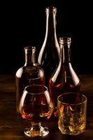 verre de whisky avec de la glace et une bouteille sur une table en bois.