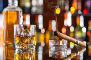 Boisson au whisky avec cigare fumant au bar photo