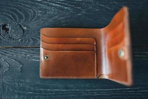 Portefeuille vintage artisanal en cuir sur fond de bois gris photo