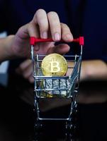 femmes d'affaires tenant un panier avec une pièce de monnaie bitcoin photo