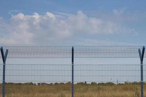 clôture de cage dans les champs, fond de ciel bleu photo