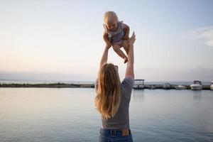 mère et fille marchant sur la jetée en bois aux beaux jours, famille heureuse sur la plage photo