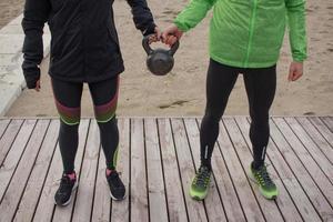 groupe de jeunes s'entraînant à l'extérieur, exercices de coureurs, arrière-plan mer ou rivière photo