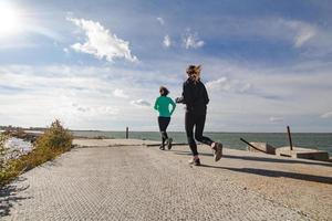 groupe de jeunes s'entraînant à l'extérieur, exercices de coureurs, arrière-plan mer ou rivière photo