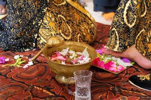 mariée javanaise traditionnelle, le processus de nettoyage des pieds du mari avec des fleurs pour les mariées javanaises photo