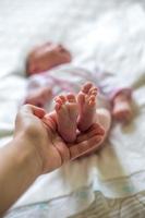 pied de bébé dans les mains de la mère