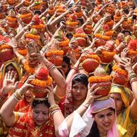 new delhi, inde 03 avril 2022 - femmes avec kalash sur la tête pendant le temple jagannath mangal kalash yatra, les dévots hindous indiens portent des pots en terre contenant de l'eau sacrée avec une noix de coco sur le dessus photo