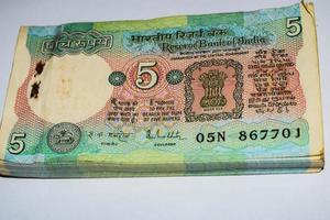 vieux billets de cinq roupies combinés sur la table, argent indien sur la table tournante. vieux billets de banque indiens sur une table tournante, monnaie indienne sur la table photo