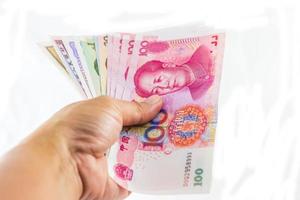 monnaie yuan chinois en main sur fond blanc