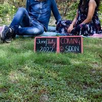 couple indien posant pour une séance photo de maternité. le couple pose dans une pelouse avec de l'herbe verte et la femme étale sa bosse de bébé dans le jardin de lodhi à new delhi, inde