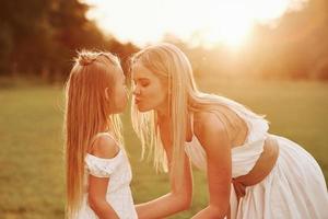 elle aime son enfant. mère et fille profitant du week-end ensemble en marchant à l'extérieur sur le terrain. belle nature photo