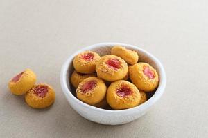 biscuits à empreinte de pouce remplis de confiture de fraises et de fromage râpé. familier pendant le mois de ramadan et eid fitri. photo