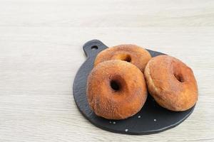 donat kentang, beignet de pommes de terre, beignets avec des ingrédients de pommes de terre ajoutés. saupoudré de chocolat en poudre et servi sur une petite assiette. photo