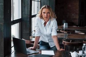 êtes-vous prêt à commencer une journée de travail. femme d'affaires aux cheveux blonds bouclés à l'intérieur dans un café pendant la journée photo