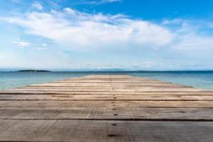 terrasse en bois vintage sur la plage avec mer bleue, océan, fond de ciel photo