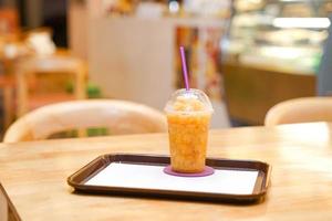 smoothie aux fruits de la passion dans une tasse en plastique à emporter au restaurant. photo