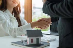 agent immobilier et client se serrant la main après la fin du contrat après avoir parlé d'assurance habitation et de prêt d'investissement photo