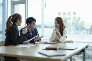 l'équipe de concepteurs de groupes de travail d'affaires asiatiques avec une femme leader asiatique discute des données statistiques du rapport financier de la paperasserie, prévoit de travailler sur un projet commun. remue-méninges, concept d'activité d'information photo